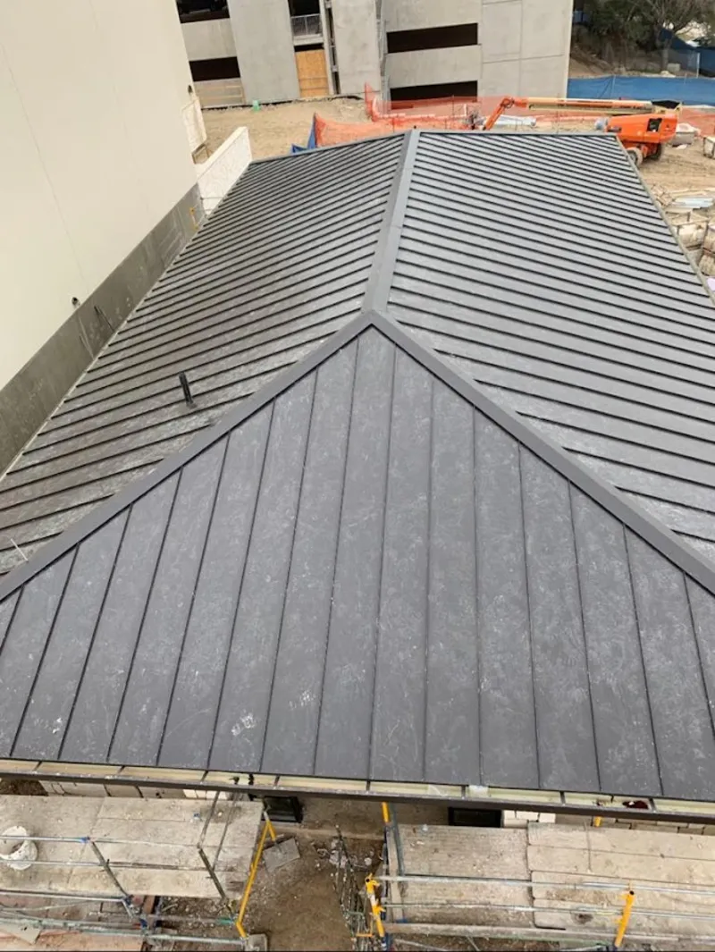 Commercial metal roof construction with crane equipment in Center Point